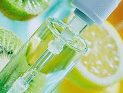 A dropper bottle filled with clear liquid is shown in front of sliced kiwi and lemon.